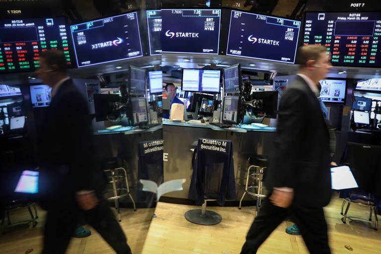 Operadoras da NYSE, bolsa de valores dos EUA, com telão de ações ao fundo