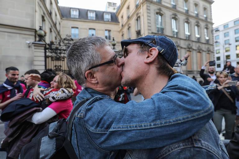 Ativistas pelos direitos LGBTQ se beijam durante protesto em frente à embaixada de Brunei em Paris