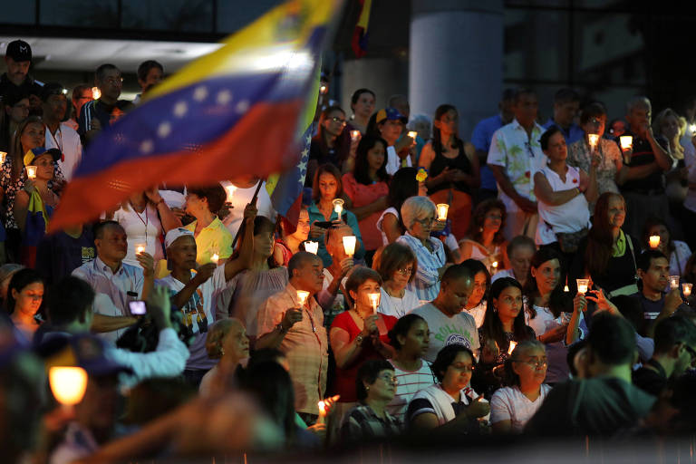 Manifestantes seguram velas e bandeiras a Venezuela durante vigília em homenagem a vítimas dos protestos em Caracas