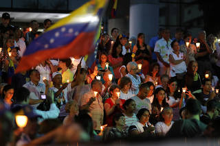 People attend a candlelight vigil held for victims of recent violence in Caracas