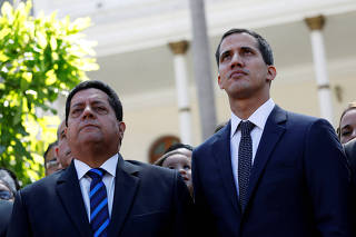 FILE PHOTO: Juan Guaido, new President of the National Constituent Assembly and lawmaker of the Venezuelan opposition party Popular Will, and lawmaker Edgar Zambrano of Democratic Action party, leave the congress in Caracas