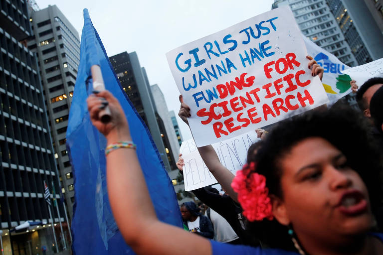 Em São Paulo, estudante exibe cartaz em que pede verbas para a realização de pesquisas científicas