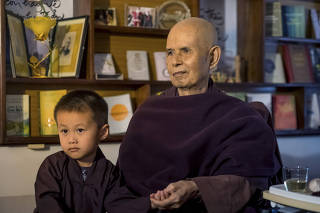 Thich Nhat Hanh with a child of one of his followers at Tu Hieu Temple in Hue, Vietnam.