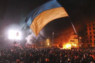 Pro-European protesters gather around burning vehicles during clashes with Ukrainian riot police in Kiev