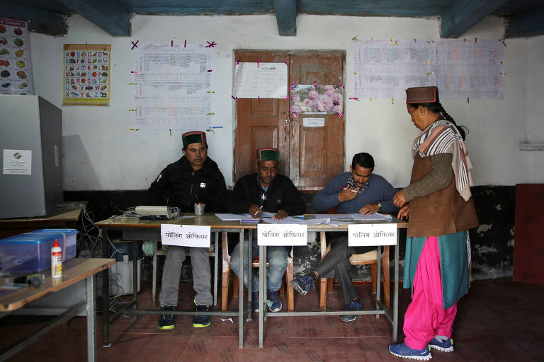 Mulher vota em seção eleitoral durante a fase final das eleições na Índia, neste domingo (19)