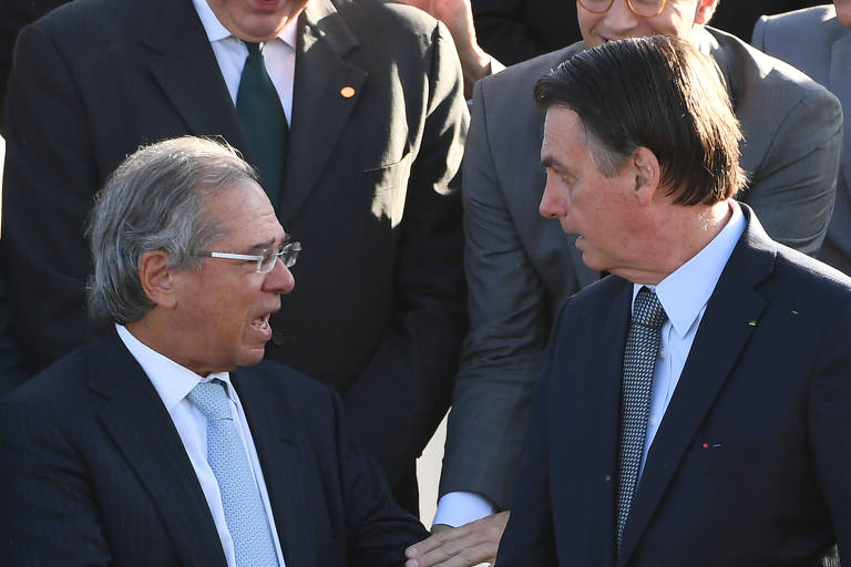 Ministro da Economia, Paulo Guedes, e Presidente da República, Jair Bolsonaro, em cerimônia do hasteamento da bandeira nacional no Palácio do Alvorada