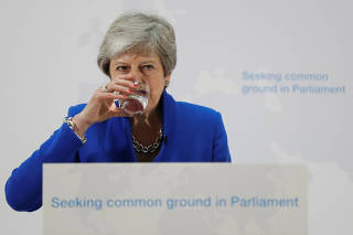 Britain's Prime Minister Theresa May drinks water while delivering a speech on Brexit in London