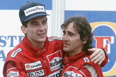 (FILES) In this file photo taken on November 12, 1988, new world champion Ayrton Senna (L) of Brazil embraces his team mate and winner of Australian Grand Prix Alain Prost of France , in Adelaide. - May 1 marks the 25th anniversary of Sennas dead. The F1 legend died after crashing in the seventh lap of the Italy's San Marino Grand Prix at Imola's Tamburelo curve. (Photo by - / AFP)