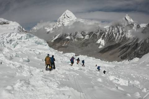 (FILES) In this file photo taken on April 29, 2018, mountaineers walk near camp one of Mount Everest, as they prepare to ascend on the south face from Nepal. - Three more climbers have died on Everest, expedition organisers and officials said Friday, taking the toll from a deadly week on the overcrowded world's highest peak to seven. (Photo by Phunjo LAMA / AFP) ORG XMIT: PRA262