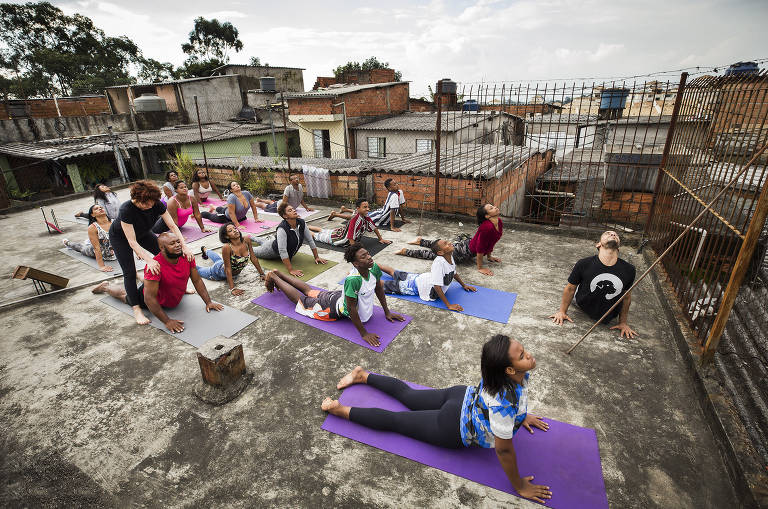 Moradores durante sessão de ioga em laje da favela Sabin, no Capão Redondo, na zona sul de São Paulo