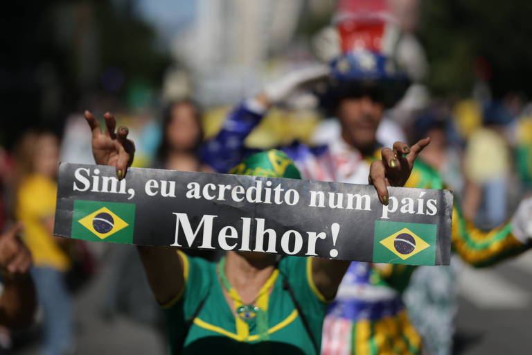 O cartaz, que traz bandeirinhas do Brasil,  diz o seguinte: "Sim, eu acredito num país melhor". 