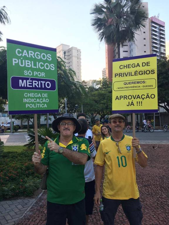 Em Fortaleza, apoiadores de Bolsonaro seguram cartazes com frases que lembram discursos de Bolsonaro enquanto candidato