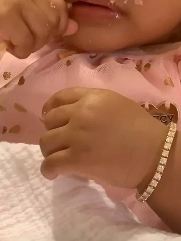 bebê com pulseira de pedras preciosas