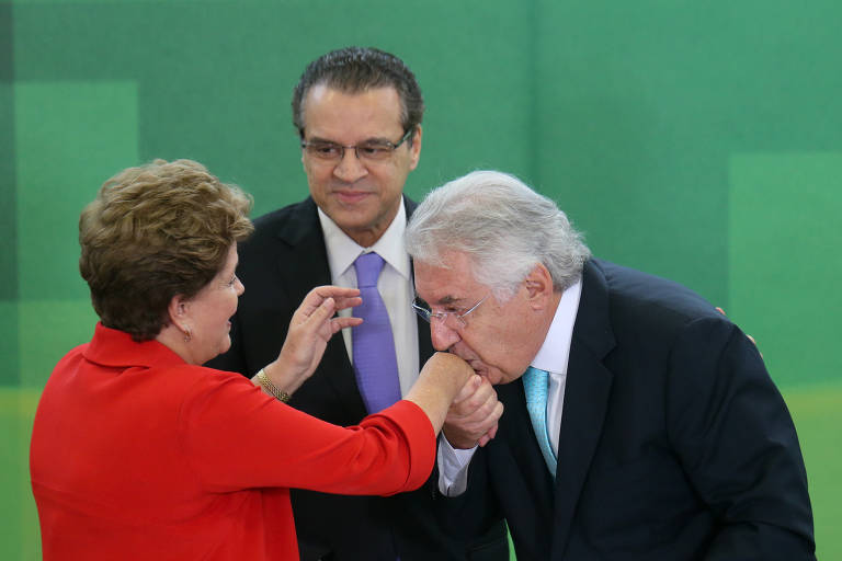 BRASÍLIA, DF, BRASIL, 07.08.2014. às 11H30.  A presidente Dilma Rousseff sanciona, em cerimônia, lei que estende o Supersimples a mais 140 atividades do setor de serviços que hoje não estão no regimes O ministro Guilherme Afif beija a mão de Dilma, sendo observado pelo deputado Henrique Eduardo Alves.(FOTO Alan Marques/ Folhapress) PODER