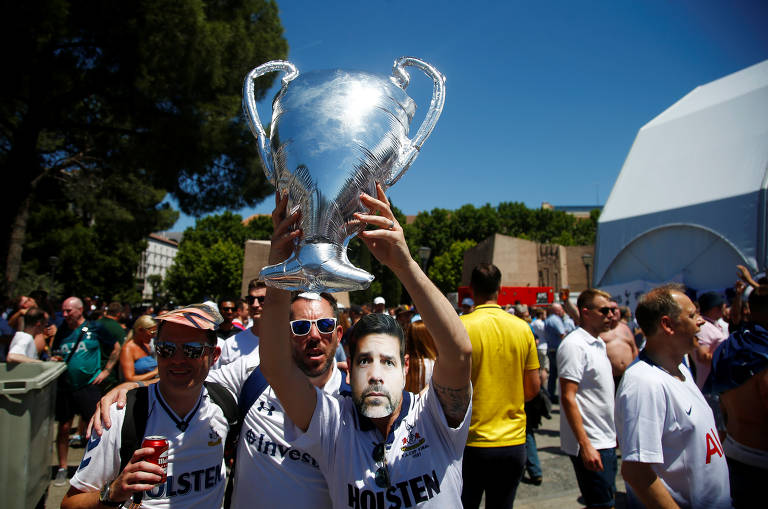 Torcedores do Tottenham, em Madri, com máscara do treinador Maurício Pochettino e uma réplica da taça da Champions League