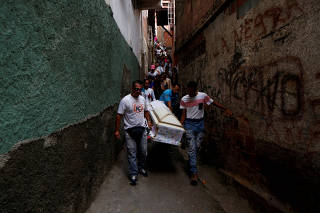 Relatives carry a coffin containing the body of Erick Altuve, a 11-year-old boy who died from respiratory problems while in care for stomach cancer at the public Jose Manuel de los Rios hospital, at Petare neighborhood in Caracas