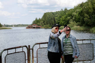 Visitors take a selfie at a river port of the abandoned city of Pripyat, near the Chernobyl nuclear power plant
