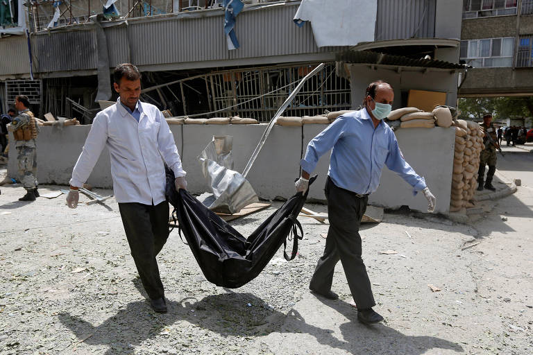 Dois paramédicos carregam corpo de vítima de atentado em um saco preto em Cabul (Afeganistão), em 2017