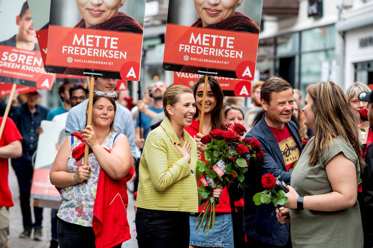 A líder social-democrata Mette Frederiksen (de amarelo), que deve ser a próxima primeira-ministra, cumprimenta eleitores em Aalborg