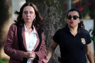 Andrea Neves, sister of Brazilian Senator Aecio Neves, is escorted by a federal police officer as she arrives to the Institute of Forensic Science in Belo Horizonte