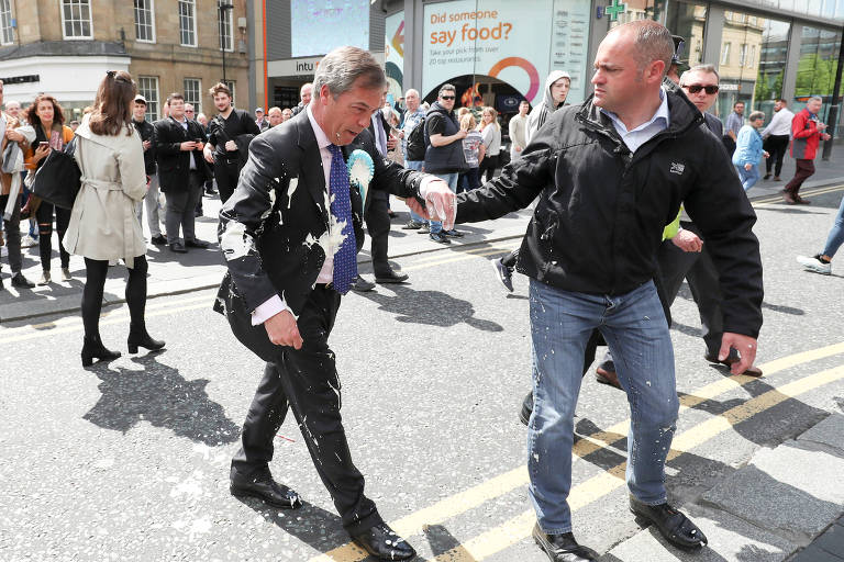 Nigel Farage é amparado após ser atingido por milk-shake em Newcastle, na Inglaterra