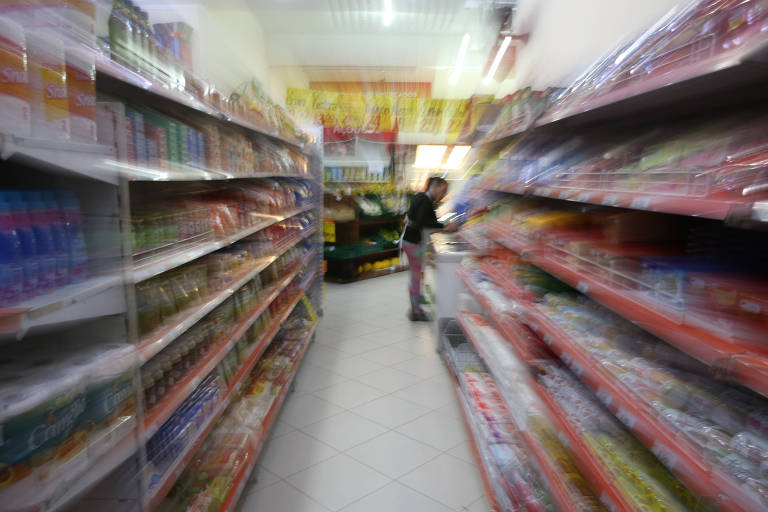 Consumidor analisa produto em prateleira de supermercado em São Paulo