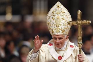 Pope Benedict XVI waves as he leaves at the end of the Christmas mass in Saint Peter's Basilica at the Vatican