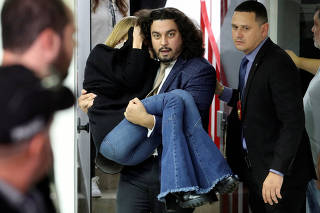 Najila Trindade de Souza, who accuses Brazilian soccer player Neymar of rape, is carried by her lawyer Danilo Garcia de Andrade after giving testimony in a police station, in Sao Paulo