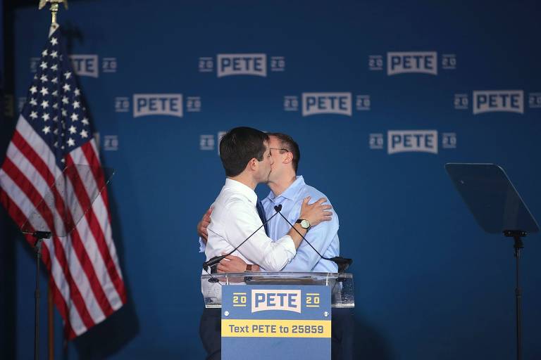 Pete Buttigieg (esq.) beija Chasten ao lançar sua pré-candidatura, em South Bend (Indiana)