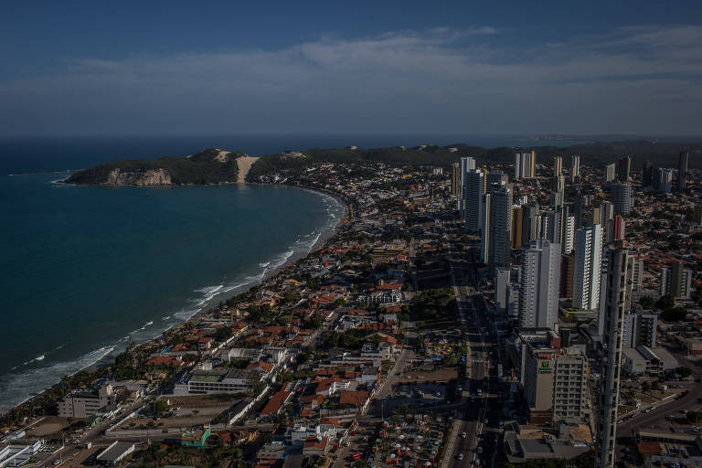 Vista aérea da zona sul de Natal, no Rio Grande do Norte, com o mar à esquerda, a faixa de praia e uma área urbana