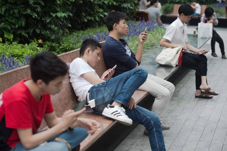 Jovens usam smartphones em Shenzhen, no sul da China