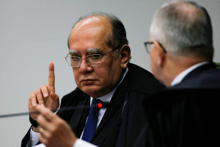 Retrato de Gilmar Mendes, presidente do STF, durante sessão. Ele levanta o dedo indicador