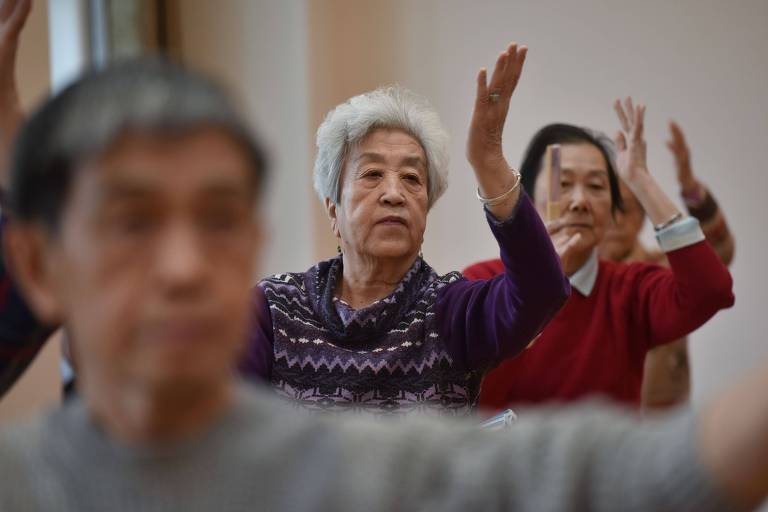 Chineses idosos participam de aula de dança 