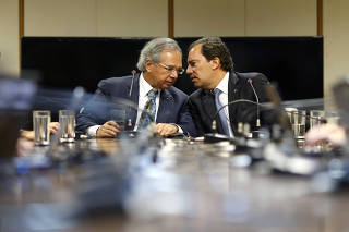 Brazil's Economy Minister Paulo Guedes talks with Caixa Economica Federal Bank President Pedro Guimaraes during a news conference in Brasilia