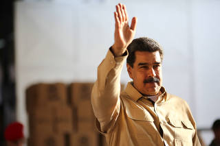 Venezuela's President Nicolas Maduro waves during his visit to a packing center of the CLAP (Local Committees of Supply and Production) program, a Venezuelan government handout of basic food supplies, in Caracas