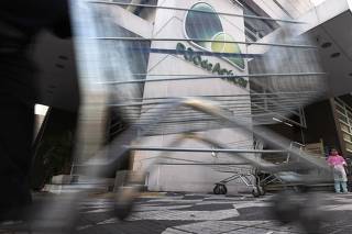 Worker pushes a shopping trolley at the entrance of Pao de Acucar supermarket in Sao Paulo