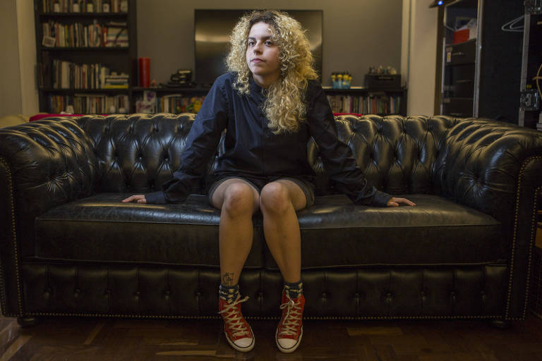 Estela May, quadrinista da Folha de 18 anos, sentada no sofá da sala de sua casa, em São Paulo. 