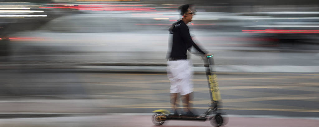 Usuário de patinete elétrico circula no cruzamento entre as avenidas Faria Lima e Juscelino Kubitschek, na zona oeste de São Paulo