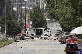 Damaged vehicles are seen at the the site of a blast in Kabul