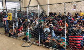 An overcrowded fenced area holding families at a Border Patrol station is seen in McAllen
