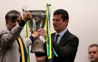 O deputado Boca Aberta entre troféu ao ministro Sergio Moro