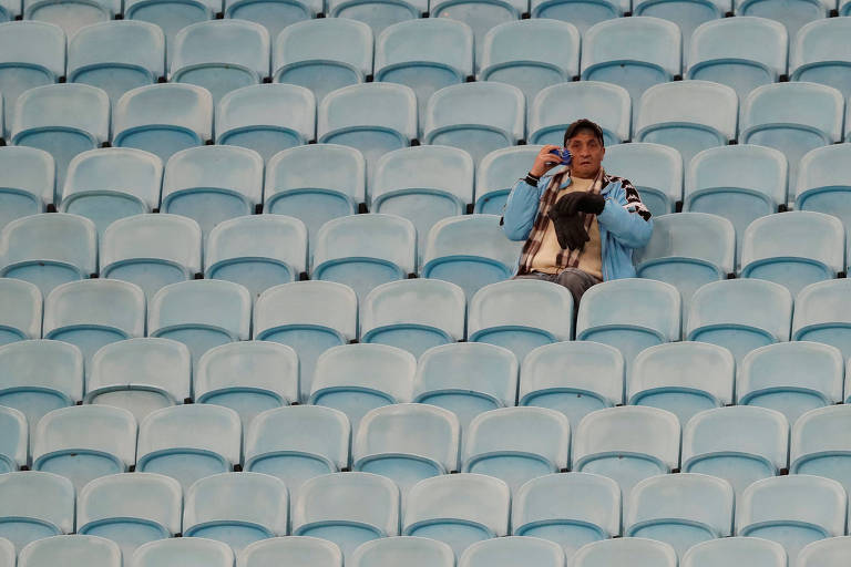 Torcedor solitário, rodeado de cadeiras vazias, na Arena do Grêmio antes de jogo entre Chile e Peru, pela semifinal