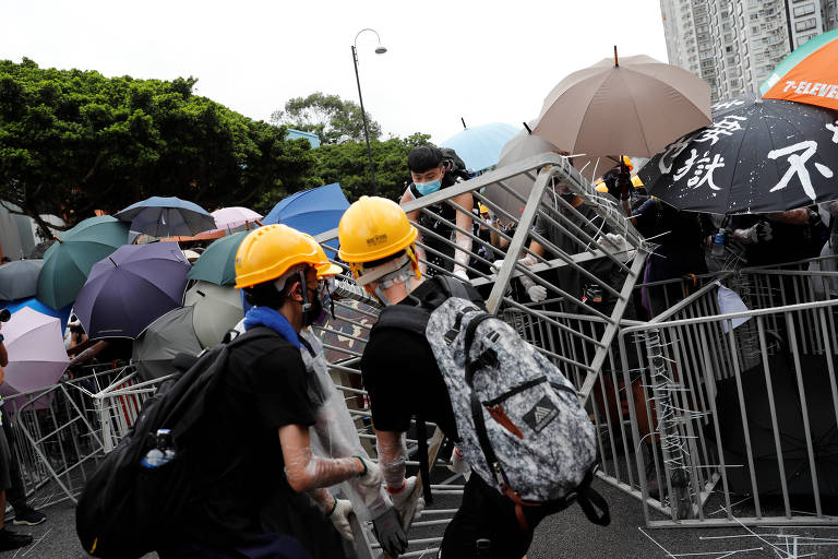 Manifestantes fazem barricadas com cercas de metal para se protegerem da polícia de Hong Kong