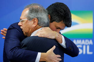 Brazil's Economy Minister Paulo Guedes greets Gustavo Henrique Moreira Montezano during his inauguration ceremony as the new Brazilian National Development Bank (BNDES) President at the Planalto Palace in Brasilia