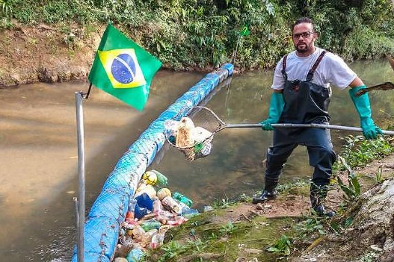 Vendedor gastou cerca de mil reais com a construção da barreira; ele mantém o rio limpo tirando o lixo acumulado na ferramenta que construiu
