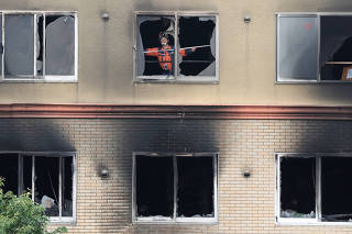 A firefighter inspects the interior of the torched Kyoto Animation building in Kyoto