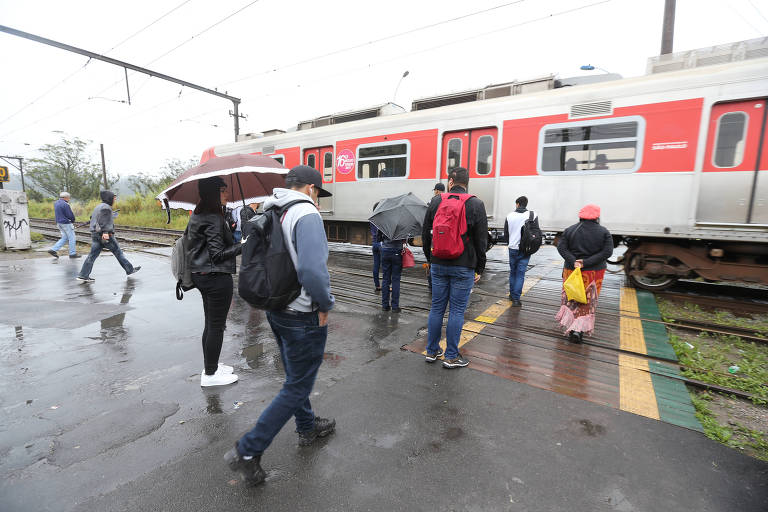 Passageiros atravessam linha de trem na estação Rio Grande da Serra (ABC), da linha 10-turquesa; passarela foi retirada do local