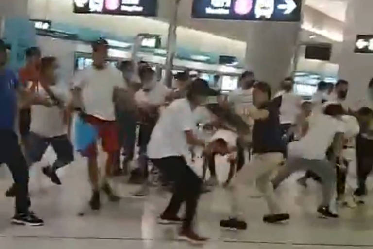 Imagem tirada de vídeo mostra agressões em estação de Hong Kong; homens de camiseta branca seriam membros de gangues da 'máfia' chinesa, segundo suspeitas