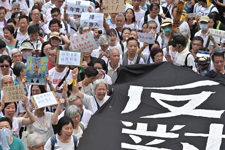 Idosos carregam faixa em ato em apoio aos protestos liderados por jovens em Hong Kong 
