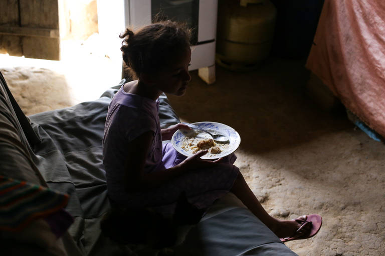 No povoado de Lagoa Preta, Marizete, 7, come prato servido pela mãe, Dalva Novaes Viana, 47. Em 2017, 15 pessoas morreram por dia de desnutrição, e 37% das mortes ocorreram no Nordeste